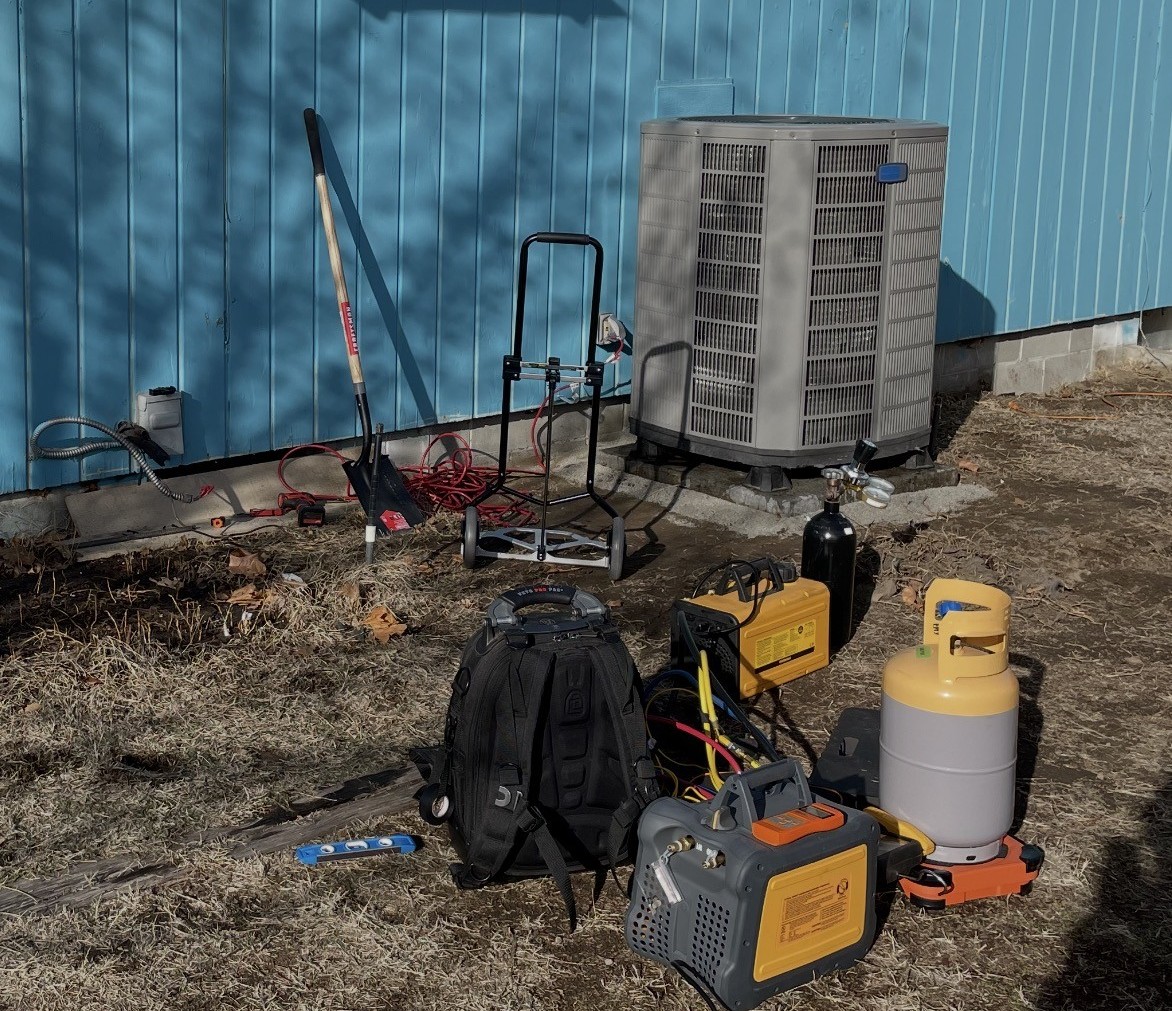 Outdoor central air conditioning unit being serviced at a Tri-Cities area home.