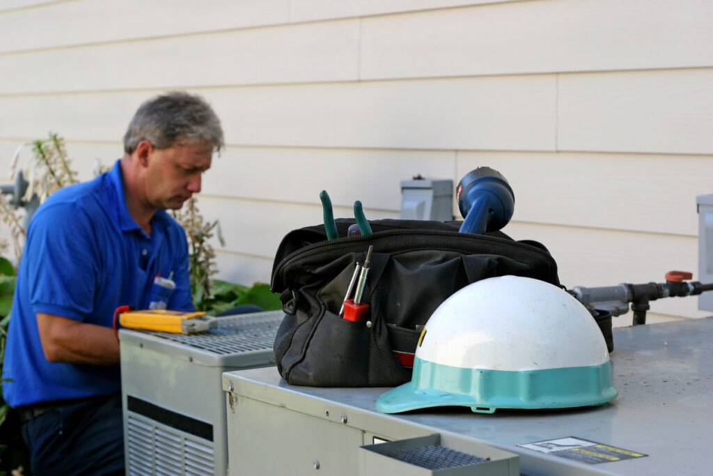 HVAC technician running a diagnostic test on an air conditioner before AC repair in Kennewick, WA