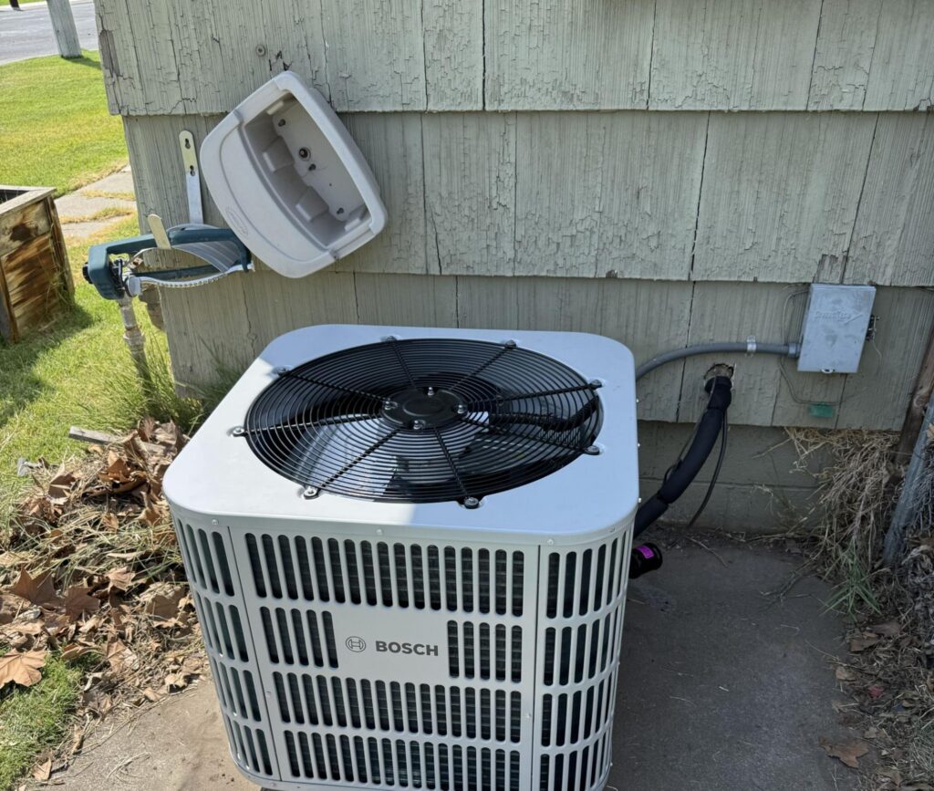 HVAC condenser unit with dry leaves and weeds at its base in Wallula, WA