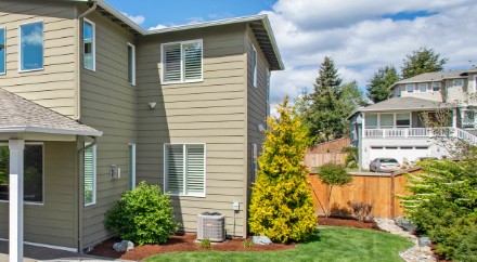 Outdoor AC condenser unit beside a two-story home in Grandview, WA